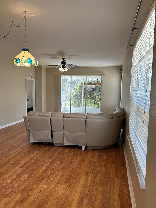 unfurnished living room featuring ceiling fan and wood-type flooring