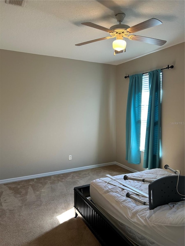 bedroom with a textured ceiling, ceiling fan, and carpet