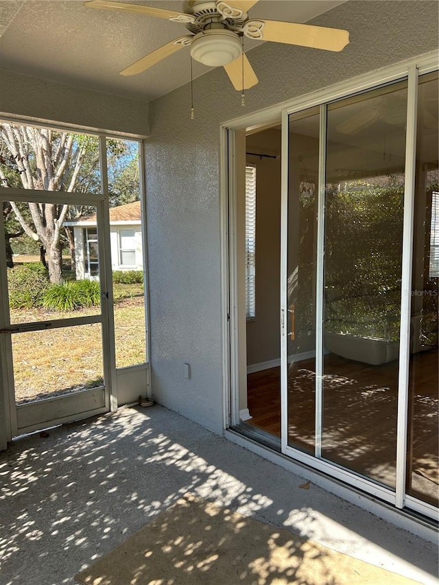 unfurnished sunroom featuring ceiling fan