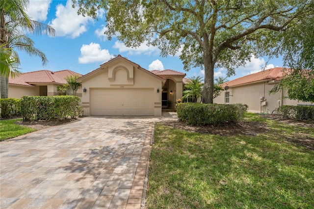 mediterranean / spanish-style home with a garage and a front yard