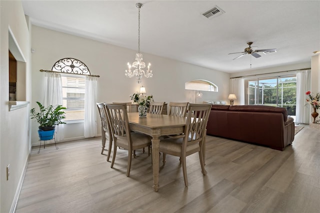 dining area featuring ceiling fan with notable chandelier and light wood-type flooring