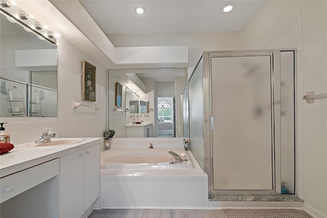 bathroom with vanity, backsplash, and separate shower and tub