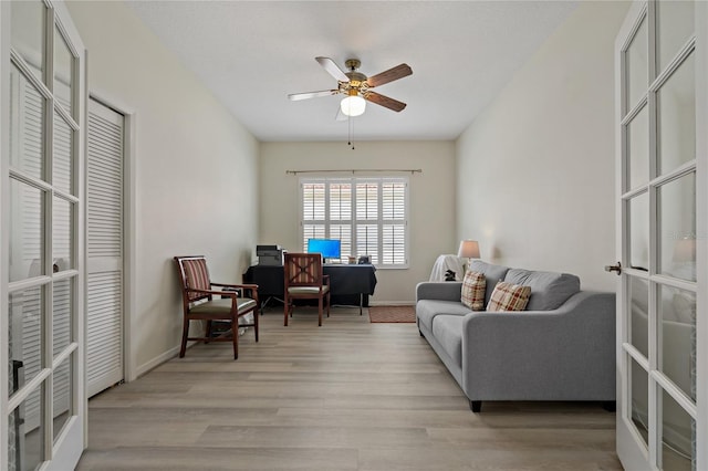 living area featuring french doors, ceiling fan, and light hardwood / wood-style flooring