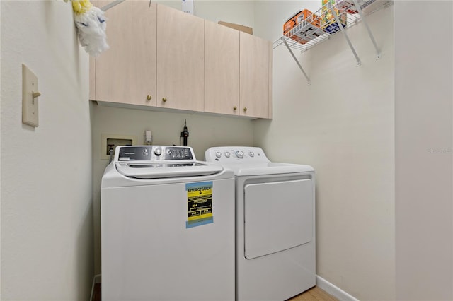 laundry area featuring washer and dryer and cabinets