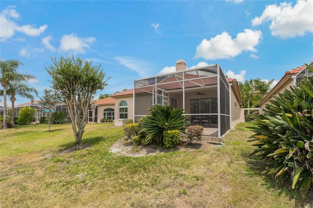 back of house featuring a yard, a lanai, and ceiling fan