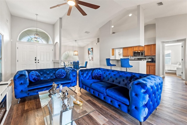 living room with ceiling fan, dark hardwood / wood-style floors, and high vaulted ceiling