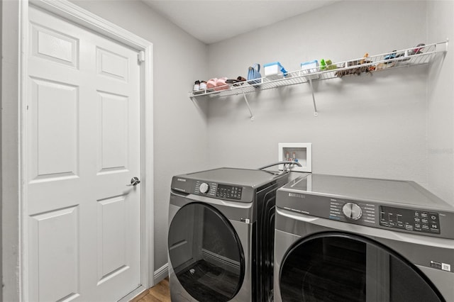 clothes washing area with wood-type flooring and independent washer and dryer