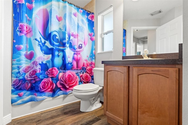 bathroom featuring wood-type flooring, toilet, and vanity