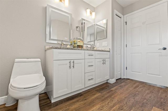 bathroom featuring vanity, hardwood / wood-style flooring, and toilet