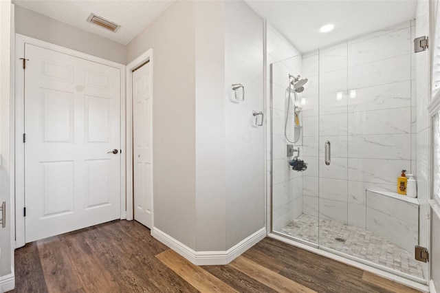 bathroom with wood-type flooring and a shower with door