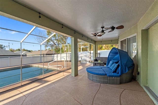 view of patio / terrace with a fenced in pool, ceiling fan, and glass enclosure