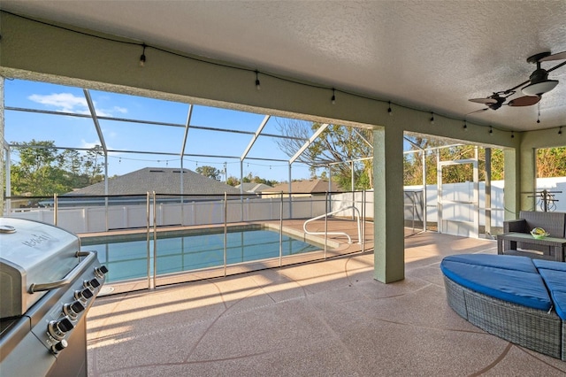 view of swimming pool featuring ceiling fan, a grill, a lanai, and a patio