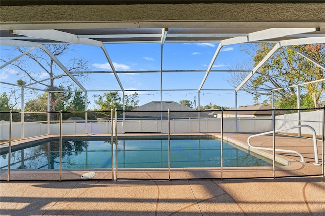 view of swimming pool featuring glass enclosure and a patio area