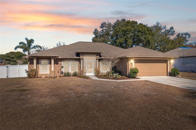 view of front of property featuring a garage and a yard