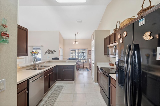 kitchen featuring hanging light fixtures, sink, dark brown cabinetry, and black appliances