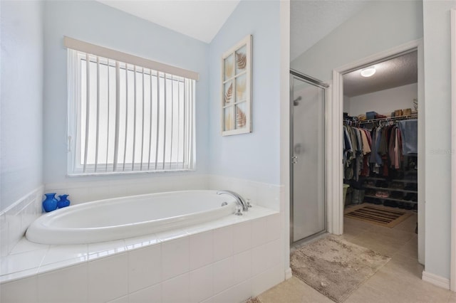 bathroom with separate shower and tub and tile patterned flooring