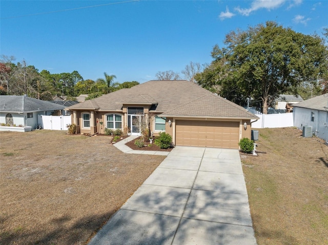 ranch-style house with central AC unit, a garage, and a front lawn