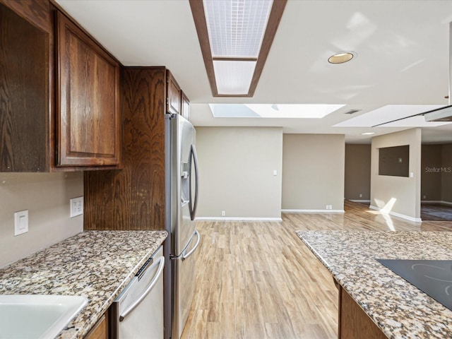 kitchen featuring light stone counters, visible vents, baseboards, appliances with stainless steel finishes, and light wood finished floors