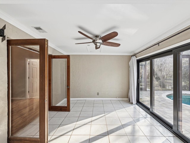 empty room with light tile patterned floors, a textured wall, visible vents, baseboards, and ornamental molding