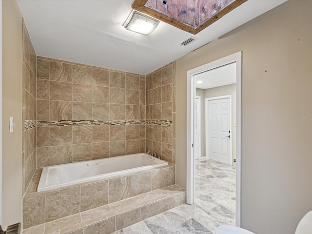 full bathroom featuring tiled tub and visible vents