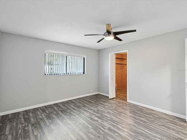 unfurnished bedroom with dark wood-style floors, baseboards, and a ceiling fan