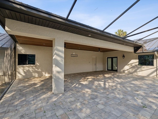 back of property with a patio, a lanai, a ceiling fan, and stucco siding