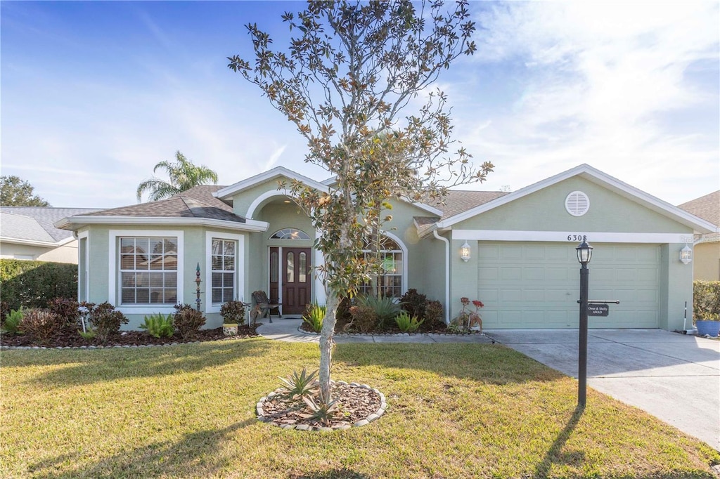 ranch-style house featuring a garage and a front yard