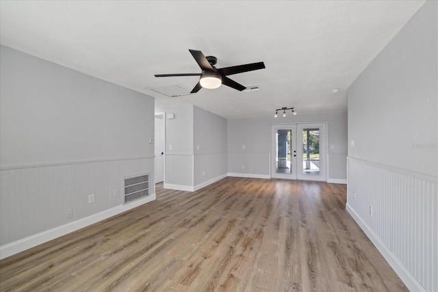 unfurnished living room featuring ceiling fan, light wood-type flooring, and french doors