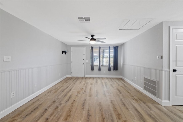 empty room with ceiling fan and light hardwood / wood-style flooring