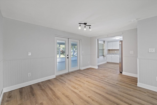 unfurnished room with french doors and light hardwood / wood-style floors