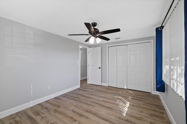 unfurnished bedroom with ceiling fan, a closet, and light hardwood / wood-style flooring