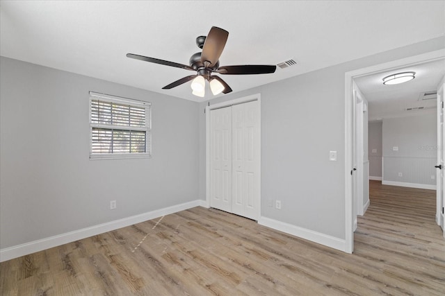 unfurnished bedroom featuring light hardwood / wood-style flooring, a closet, and ceiling fan