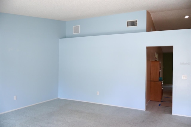 unfurnished room with light colored carpet and a textured ceiling