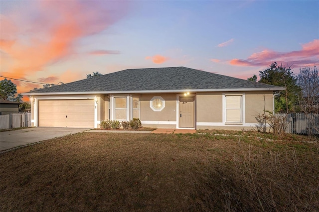 ranch-style house with a garage and a lawn