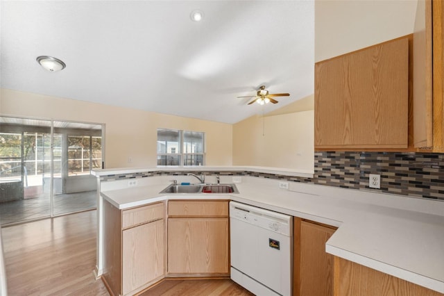 kitchen featuring white dishwasher, kitchen peninsula, sink, and decorative backsplash