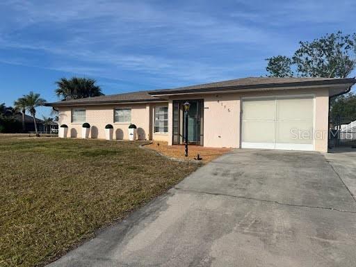 ranch-style home featuring a garage and a front lawn