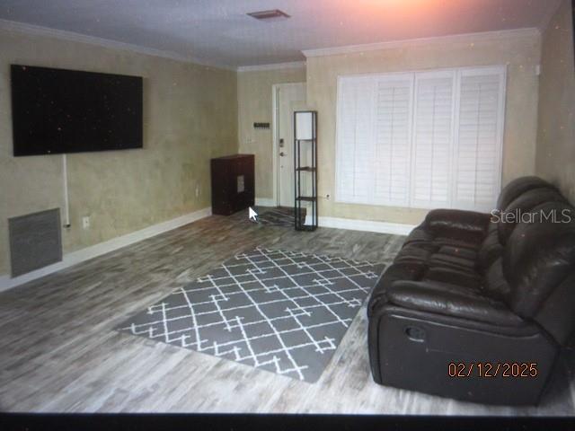 living room with hardwood / wood-style floors and ornamental molding