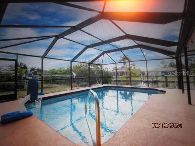 view of swimming pool with a patio area and glass enclosure