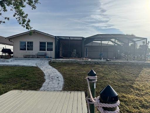 back of property featuring a yard, a lanai, and a patio