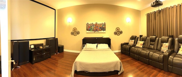 home theater room with dark wood-type flooring and vaulted ceiling