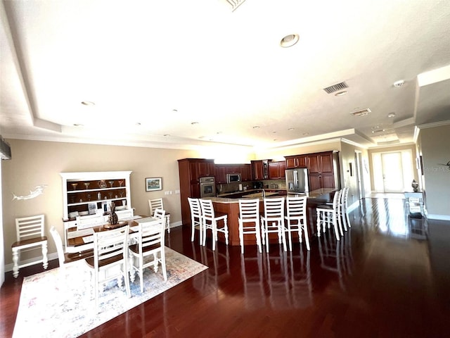 dining room with ornamental molding and dark hardwood / wood-style floors