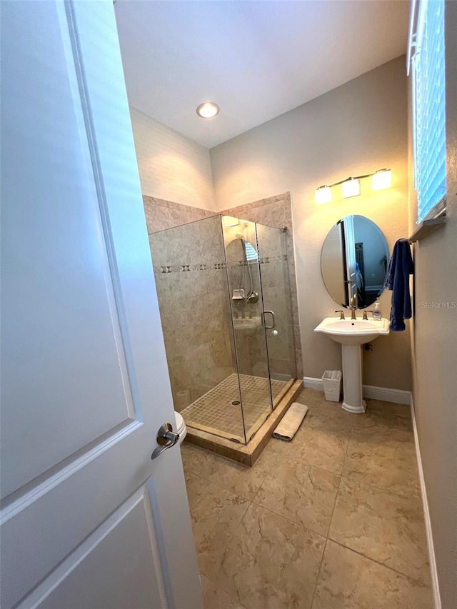 bathroom with sink and a shower with shower door