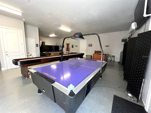 recreation room featuring an AC wall unit