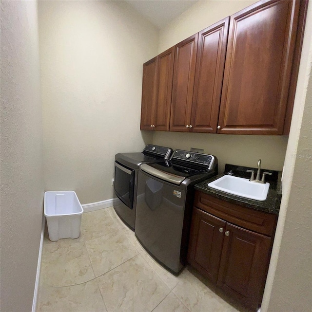 laundry room with light tile patterned flooring, cabinets, separate washer and dryer, and sink