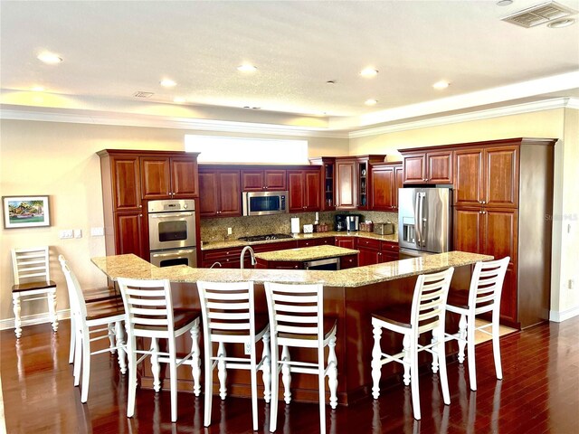 1421 Apollo Beach Blvd, Apollo Beach, FL 33572 - kitchen featuring a spacious island, appliances with stainless steel finishes, ornamental molding, visible vents, and a kitchen breakfast bar
