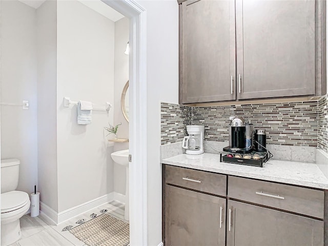 bathroom with vanity, decorative backsplash, and toilet