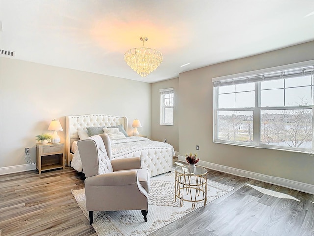 bedroom featuring hardwood / wood-style flooring and an inviting chandelier