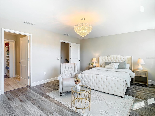 bedroom with hardwood / wood-style flooring and a notable chandelier