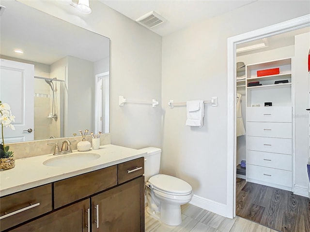 bathroom featuring vanity, toilet, and a shower with shower door