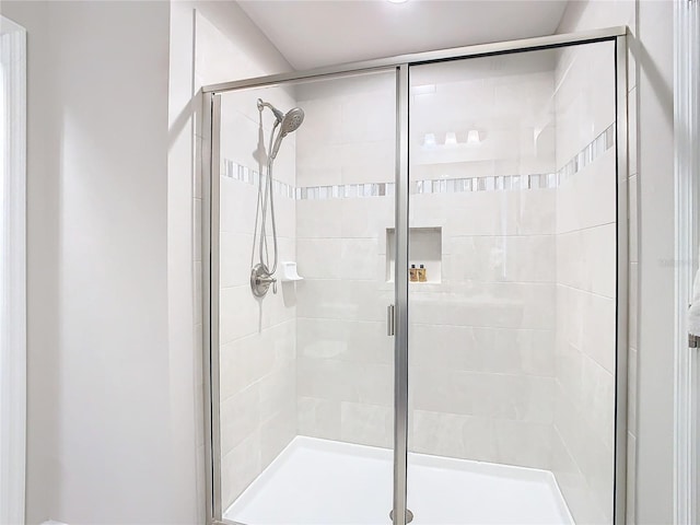 bathroom featuring a shower with door